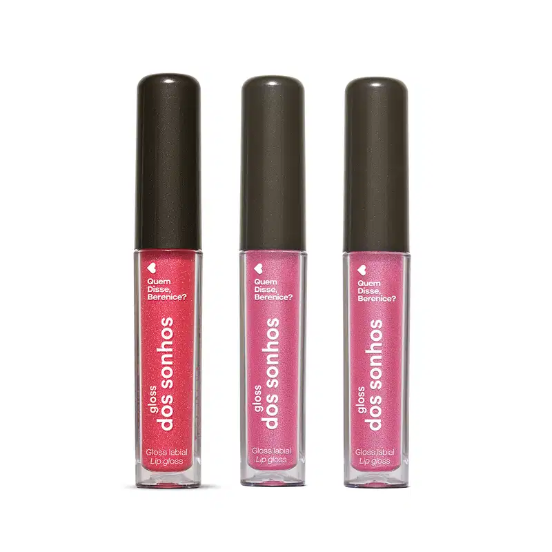 Três frascos de gloss labial da marca Gloss dos Sonhos Quem Disse, Berenice? em tons de rosa, embalagens transparentes  mostrando a cor do item, tampas pretas e rótulos exibindo o nome da marca. Cada um deles conta com 4ml do produto.