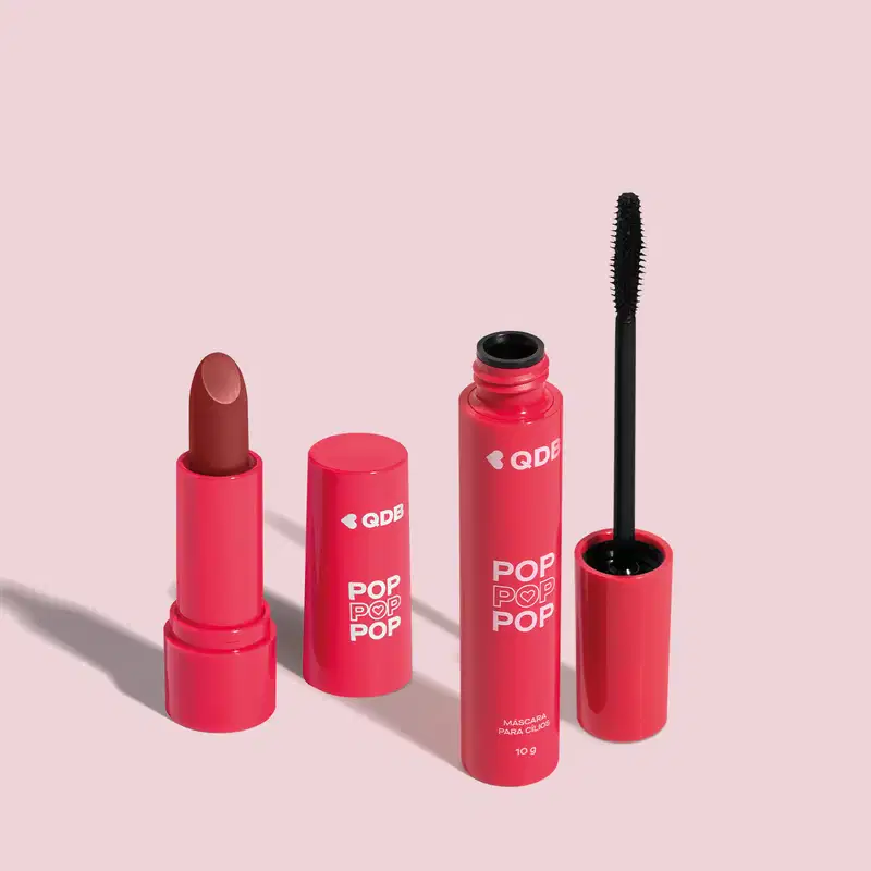 Imagem de dois produtos da marca POP Quem Disse, Berenice? contendo um batom cremoso em embalagem rosa na cor Marrom Nude e uma máscara de cílios em tubo rosa com aplicador preto. O fundo da imagem é neutro com sombreado.