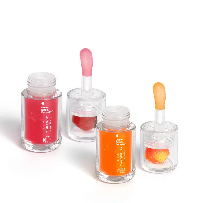 Frascos de vidro contendo batons e ólios labiais da marca Quem Disse, Berenice? em cores rosa e laranja, com rótulos indicando os nomes dos produtos.