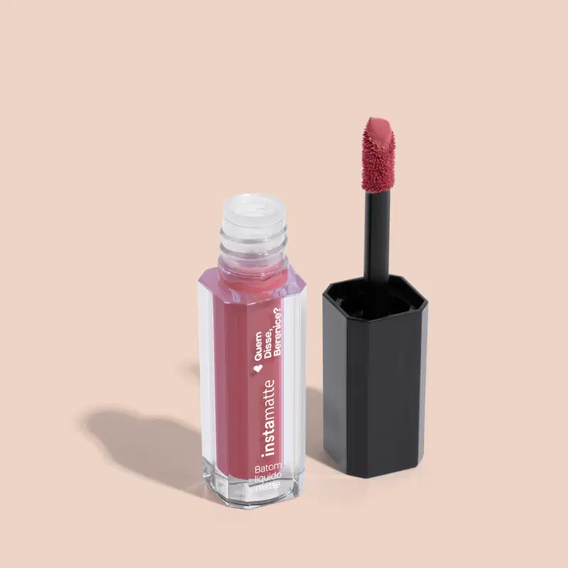 Versão miniatura do batom líquido Rose Rosetali da marca Instamatte Quem Disse, Berenice? em frasco transparente mostrando a cor do produto. Ao lado, tampa preta com aplicador rosa, tudo em fundo lilás claro.