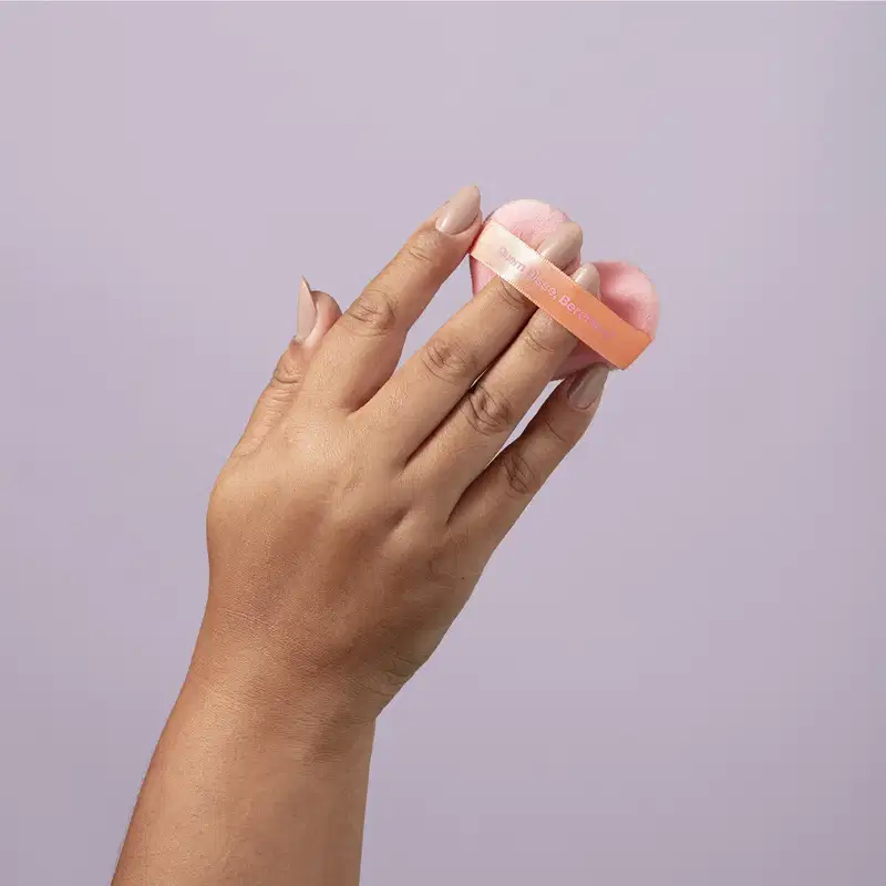O produto mostrado na imagem é um item de beleza da marca Quem Disse, Berenice? O aplicador parece ser compacto e portátil, provavelmente para facilitar a aplicação de produtos de maquiagem.