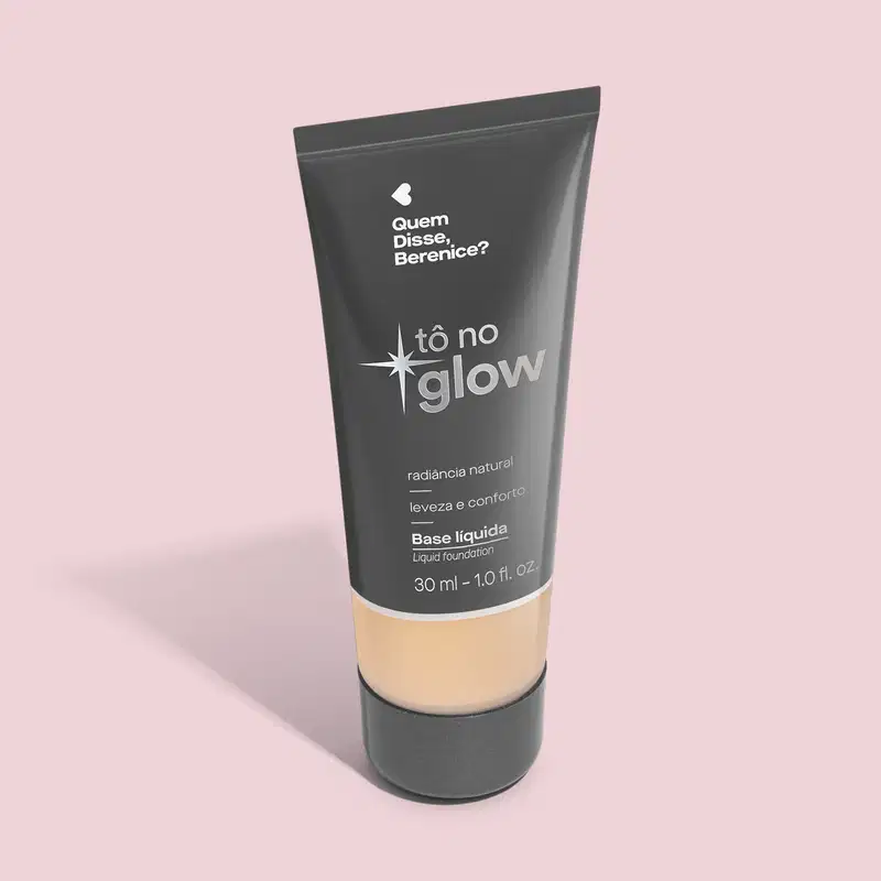 O produto apresentado é uma base líquida da marca Tô no Glow, com embalagem em tubo plástico preto e branco. O rótulo exibe o nome da marca e a descrição "Radiância natural, leveza e conforto". O produto é classificado como "Base líquida".