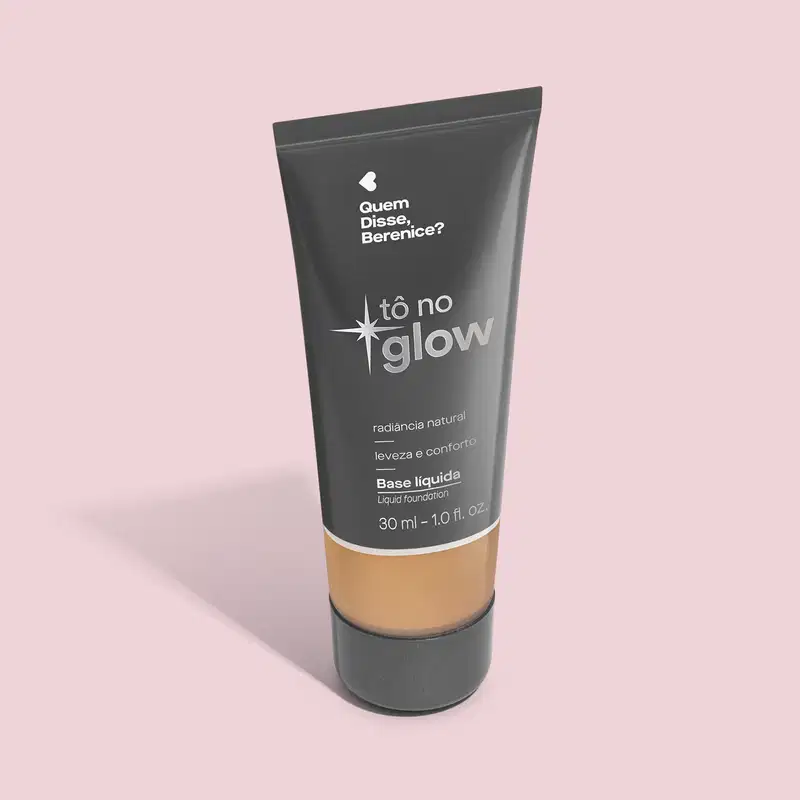 O produto apresentado é uma base líquida da marca Tô no Glow, com embalagem em tubo plástico preto e branco. O rótulo exibe o nome da marca e a descrição "Radiância natural, leveza e conforto". O produto é classificado como "Base líquida".