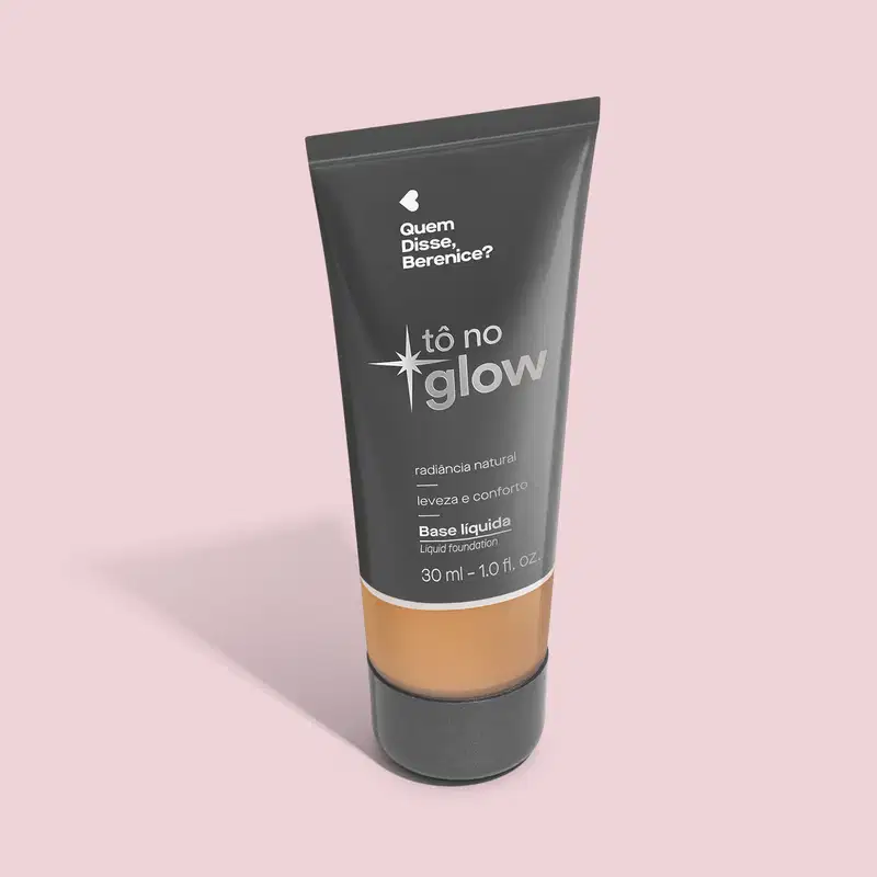 O produto apresentado é uma base líquida da marca Tô no Glow, com embalagem em tubo plástico preto e branco. O rótulo exibe o nome da marca e a descrição "Radiância natural, leveza e conforto". O produto é classificado como "Base líquida".