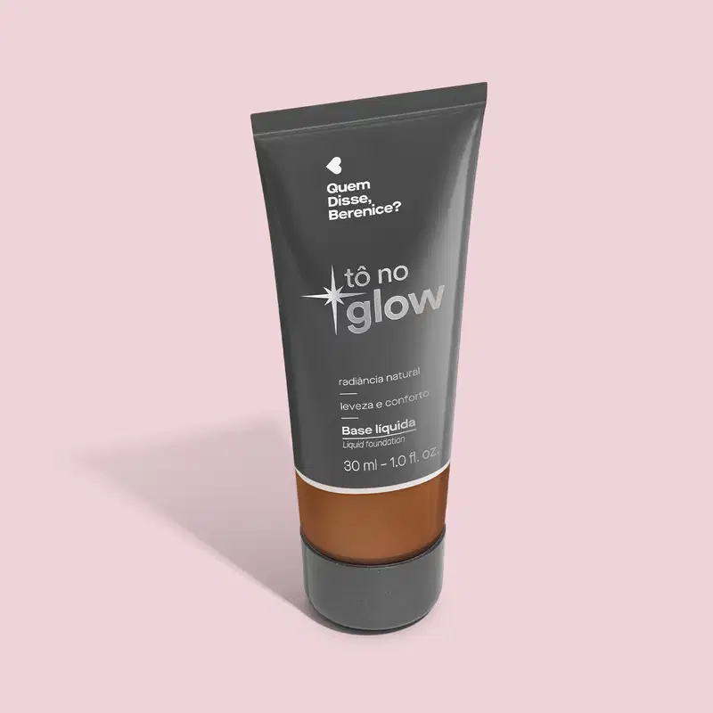O produto apresentado é uma base líquida da marca Tô no Glow, com embalagem em tubo plástico preto e branco. O rótulo exibe o nome da marca e a descrição "Radiância natural, leveza e conforto". O produto é classificado como "Base líquida".
