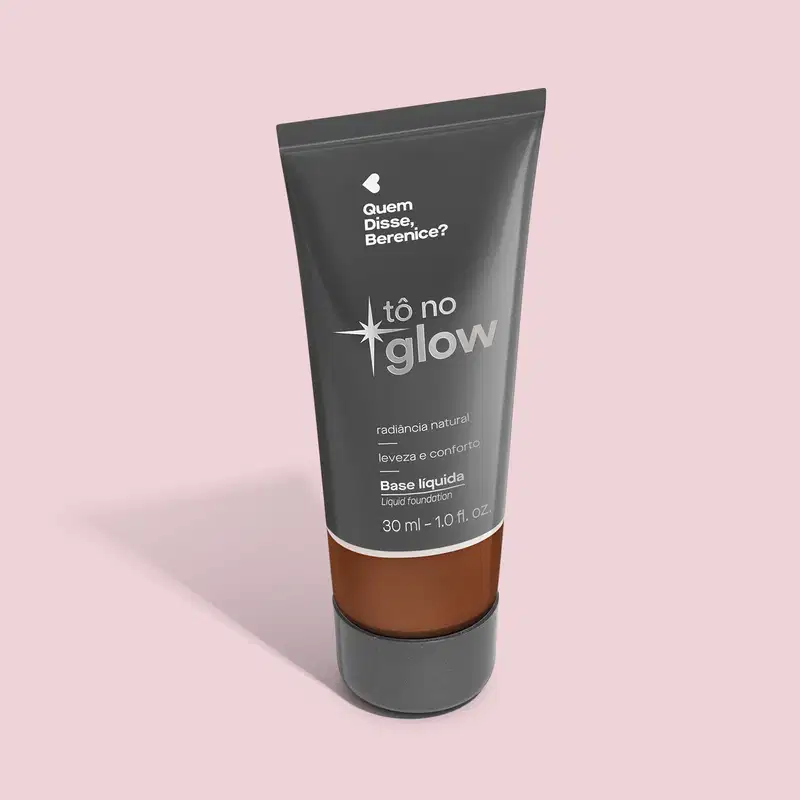 O produto apresentado é uma base líquida da marca Tô no Glow, com embalagem em tubo plástico preto e branco. O rótulo exibe o nome da marca e a descrição "Radiância natural, leveza e conforto". O produto é classificado como "Base líquida".