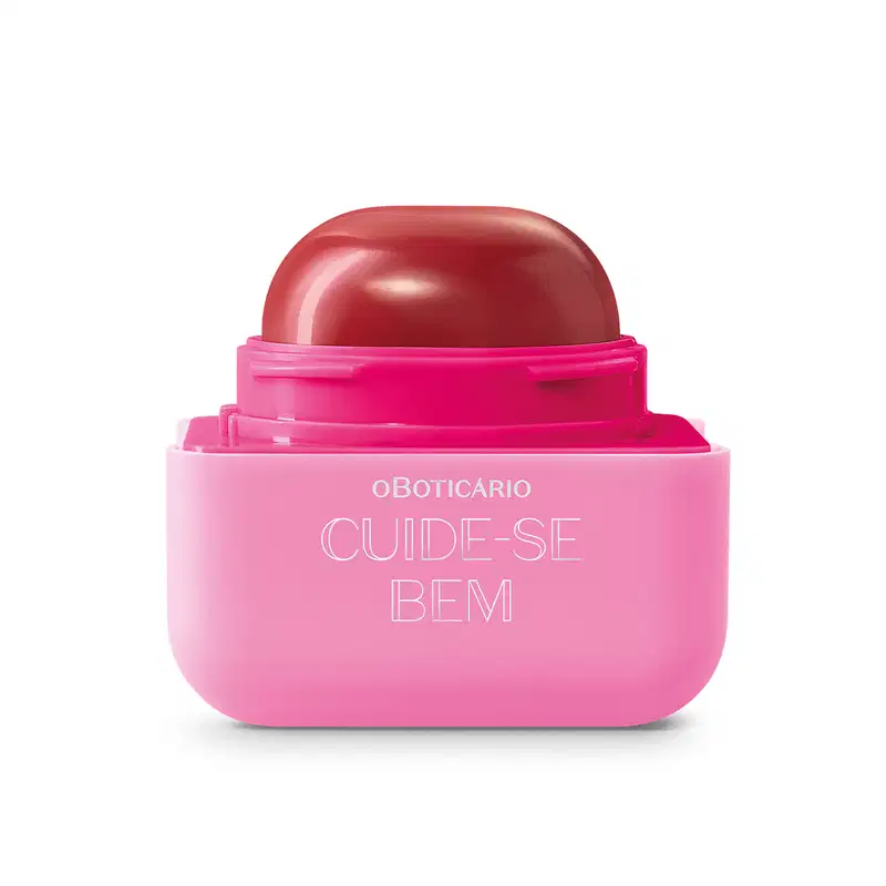 Produto de beleza em embalagem plástica rosa e vermelha. Rótulo na parte inferior rosa com o texto "OBOTICÁRIO CUIDE-SE BEM" em letras brancas.