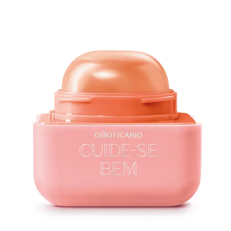 Protetor labial da marca Cuide-se Bem, com embalagem quadrada de plástico em tons de laranja claro e laranja escuro. O produto está aberto e vemos a bala em formato de semicírculo de tom alaranjado. O logo está gravado em branco na embalagem. 