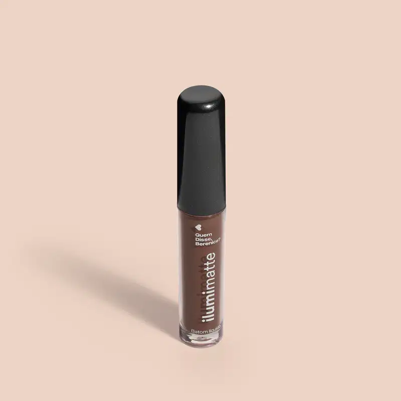 Frasco de 4ml contendo batom líquido marrom Marronlumi Ilumimatte da marca Quem Disse, Berenice? em embalagem transparente mostrando o produto na cor marrom, tampa preta e letras brancas em fundo rosado com leve sombreado.