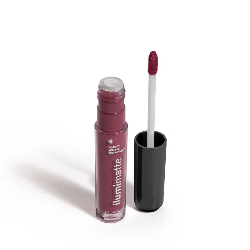 Frasco de batom líquido malva Malvalumi Ilumimatte Quem Disse, Berenice? aberto, mostrando a tonalidade do produto,, com a tampa preta ao lado que traz haste branca e esponja aplicadora na cor rosa escuro em fundo branco com leve sombreado.
