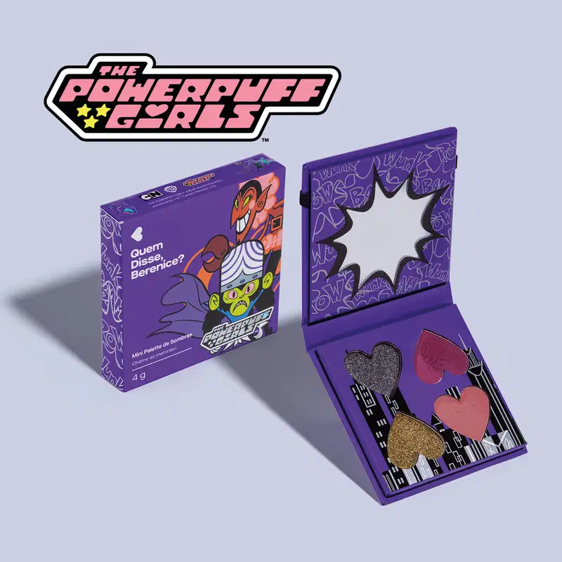Paleta de sombras compacta da marca "The Powerpuff Girls" em embalagem roxa com ilustrações e texto, contendo sombras em tons de vermelho, rosa e dourado.