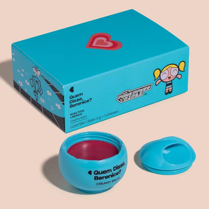Caixa azul com logotipo e personagem da série Meninas Superpoderosas, contendo um pote de balm cremoso de cor rosa com tampa azul.