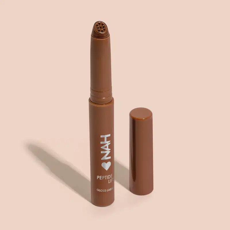 Produto de beleza em formato de batom, com embalagem marrom e rótulo com a marca "INAH" e a descrição "Peptide Lip Gloss". O produto possui uma ponta arredondada e um corpo cilíndrico, sugerindo tratar-se de um batom ou gloss labial.