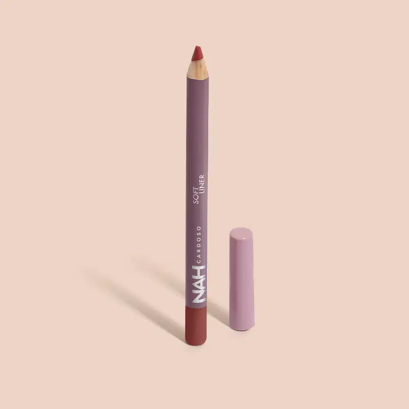Lápis de maquiagem labial da marca Nah Cardoso, em embalagem roxa com texto em branco. O lápis tem formato cilíndrico e ponta rosa, indicando a cor do produto.