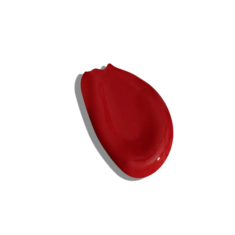 A imagem apresentada é a textura de um batom vermelho da marca Vult, num aspecto líquido e formato irregular. O batom em si não é visível.