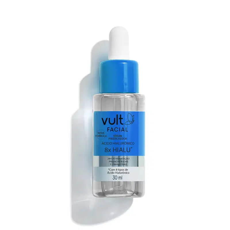 Frasco transparente arredondado contendo líquido incolor. Tampa azul e branca do tipo pipeta. Rótulo azul e branco com o nome do produto em letras pretas.