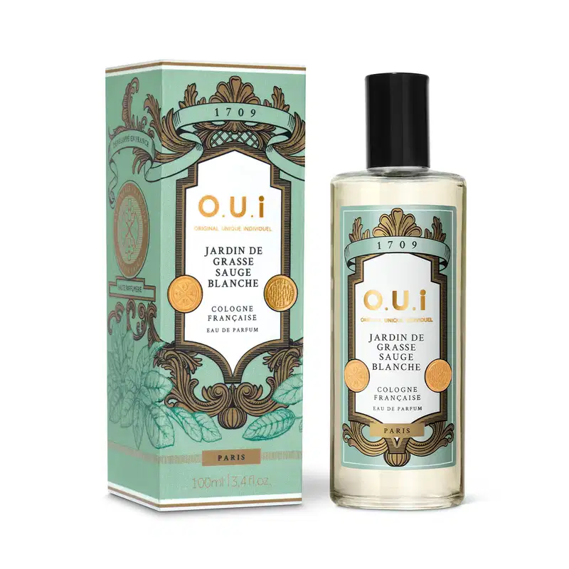 Frasco de perfume O.U.i. Jardin de Grasse Sauge Blanche ao lado da caixa, ambos com embalagem em tons de verde e dourado, exibindo ilustrações decorativas e informações sobre a fragrância.