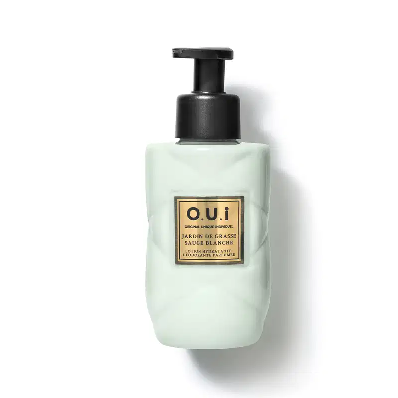 Frasco tipo pump de loção hidratante e desodorante perfumada da marca O.U.I., com embalagem de vidro na cor verde-clara e rótulo dourado com texto em francês.