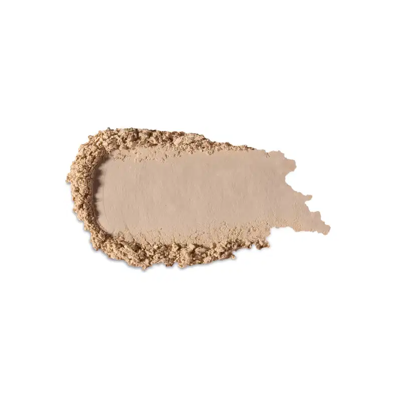 Textura bege clara de produto de maquiagem com acabamento aveludado e superfície irregular, com pequenos grânulos visíveis, indicando a textura em pó.