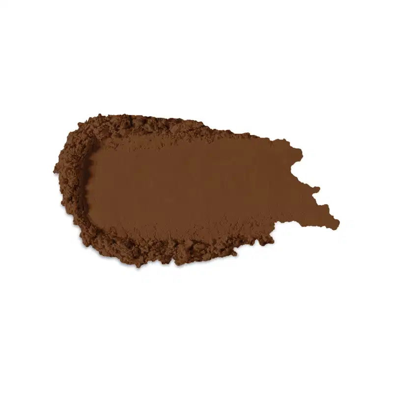 Textura no tom marrom escuro de produto de maquiagem com acabamento aveludado e superfície irregular, com pequenos grânulos visíveis, indicando a textura em pó.
