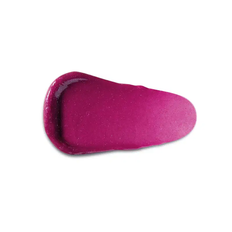 Textura rosa brilhante de item de gloss, com aparência suave e granulada, posicionado sobre superfície clara.
