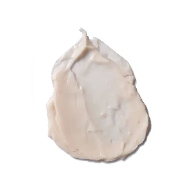 Creme corporal em formato de porção cremosa e texturizada, com coloração branca. A porção apresenta uma forma irregular e pontiaguda no topo. A superfície é lisa e brilhante, sugerindo uma consistência. Não há rótulos ou texto.