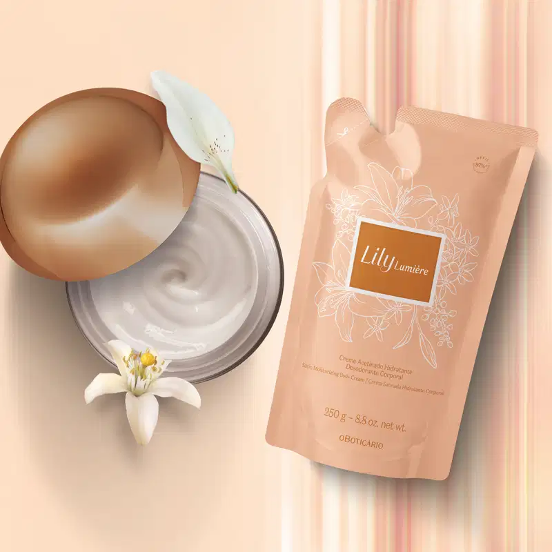 Refil de creme corporal Lily Lumière em sachê bege com flores desenhadas, pote aberto mostrando textura branca, decorado com flores brancas em fundo bege claro com cortinas rosa.