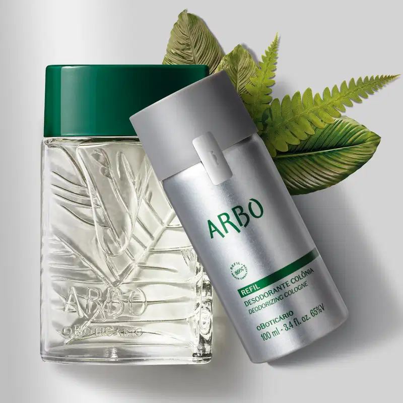 Duas embalagens contendo desodorante colônia Arbo, sendo um vidro transparente verde com folhagens em relevo e tampa verde escuro e refil em frasco prateado com tampa e letras cinzas cercados por folhas verdes e fundo cinzento claro.