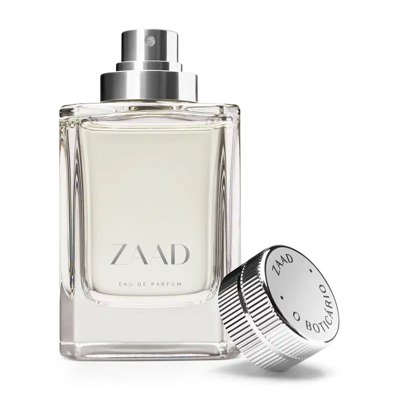 Vidro transparente com líquido cinza e pulverizador prateado e letras cinzas de Eau de Parfum Zaad. A tampa prateada está encostada ao lado da embalagem.