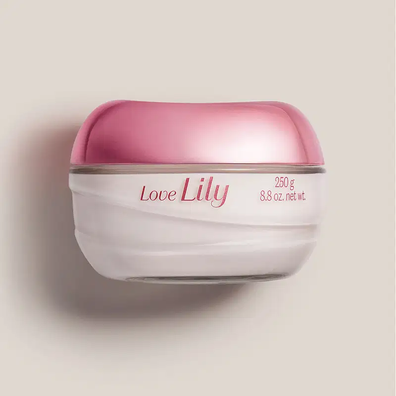 Pote de vidro transparente com creme branco, tampa roxa e letras lilás, contendo 250g de creme acetinado hidratante corporal da marca Love Lily em um fundo lilás com sombras.