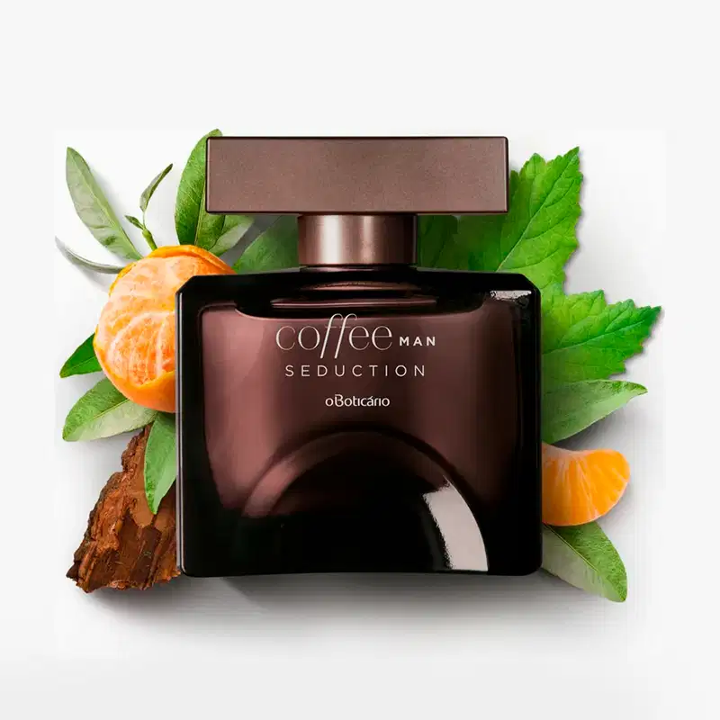 Frasco quadrado marrom com tampa retangular na mesma cor e letras cinzas, contendo desodorante colônia Coffee Man Seduction, circundado por folhas verdes, fatias de tangerina e casca de café em fundo branco.