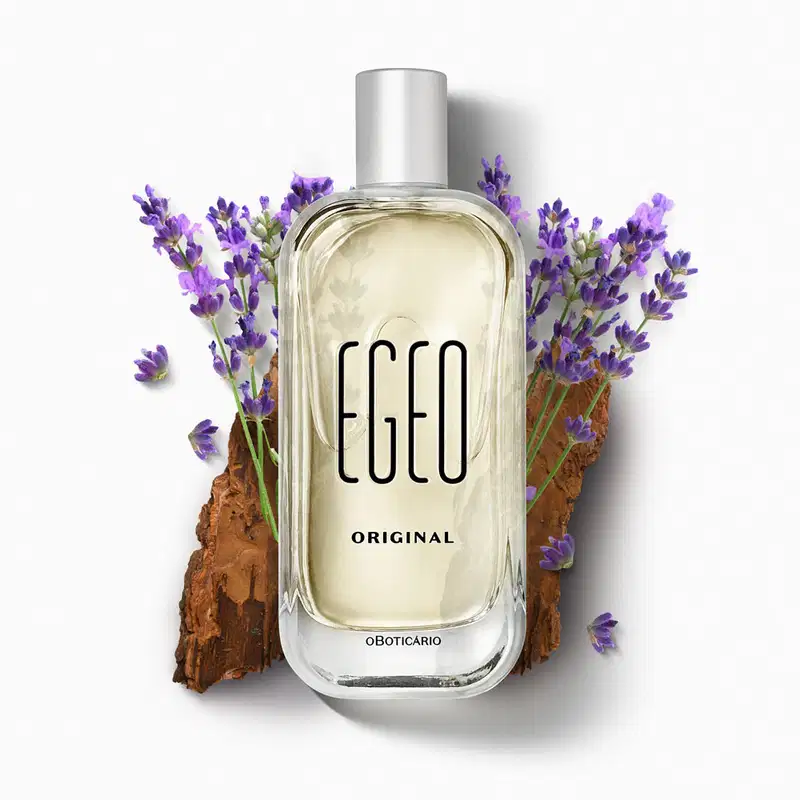 Vidro retangular com cantos arredondados, líquido bege claro, tampa prateada e letras azul-marinho em relevo de desodorante colônia Egeo Original posicionado sobre superfície com casca de cortiça e ramos de lavanda roxa ao redor, fundo branco.