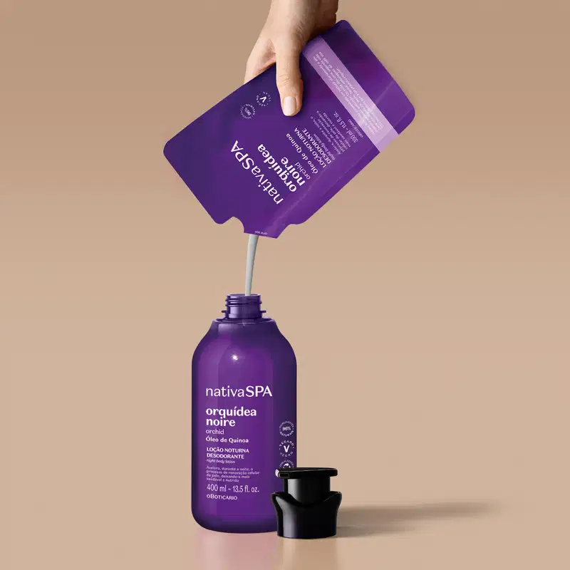 Refil de loção noturna corporal Nativa SPA Orquídea Noire em sachê na cor roxa com detalhe lilás e letras douradas e brancas despejando seu conteúdo em um frasco original do produto em tom de roxo com bomba dosadora preta. O fundo é lilás.