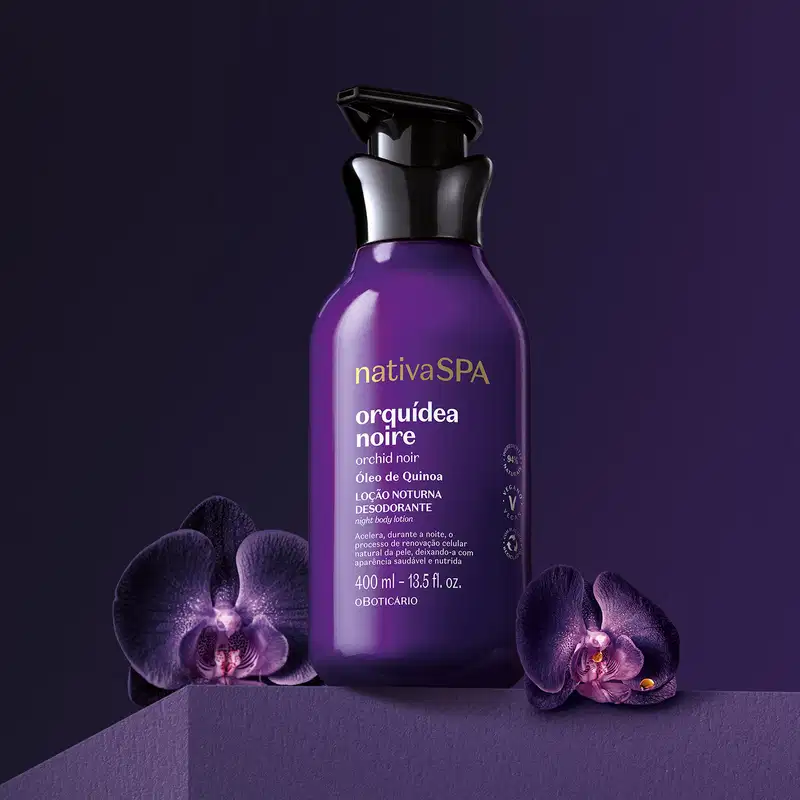 Frasco roxo com tampa dosadora preta e letras douradas e brancas de loção noturna corporal Nativa SPA Orquídea Noire está em fundo escuro com orquídeas roxas ao redor.