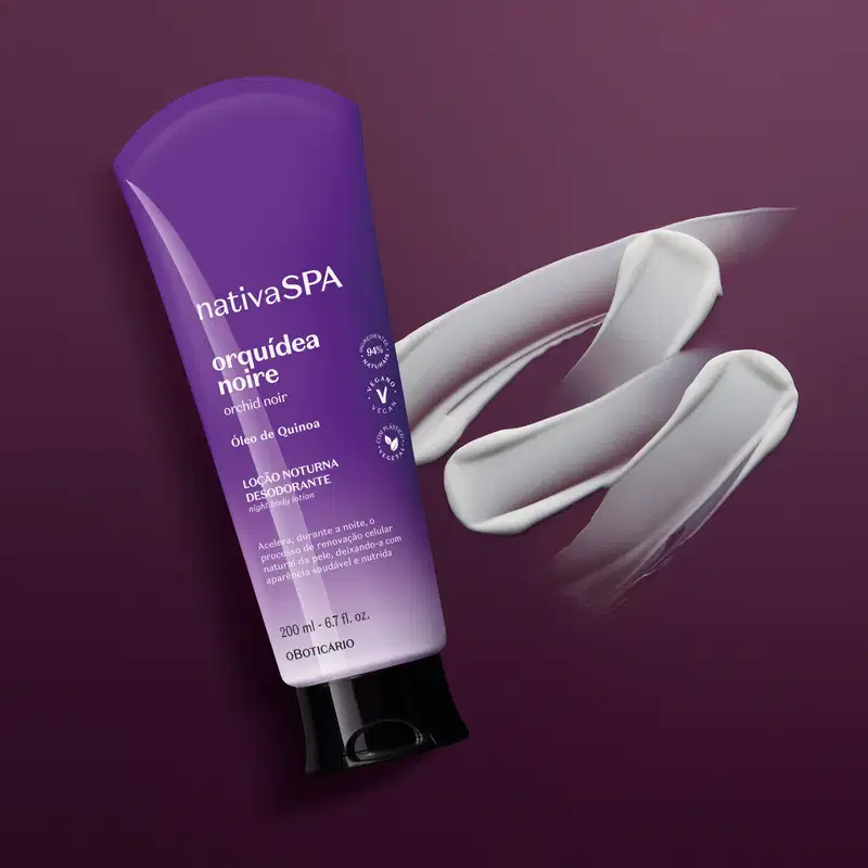 Bisnaga com degradê de roxo e branco, tampa preta e letras douradas e brancas contendo 200ml de loção noturna corporal Nativa SPA Orquídea Noire em fundo cinza escuro com uma pequena porção do produto espalhada ao lado da embalagem.