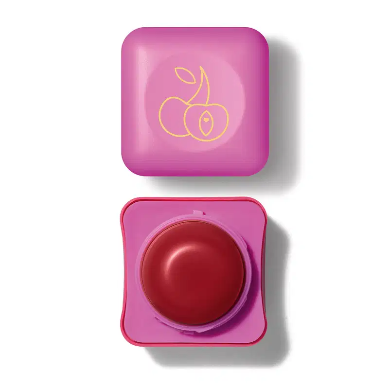 Pote compacto com cantos arredondados em tons de rosa com roll-on rosa escuro e tampa rosa com ilustração de duas cerejas contendo hidratante labial Intense & Cuide-se Bem Cereja Livre.