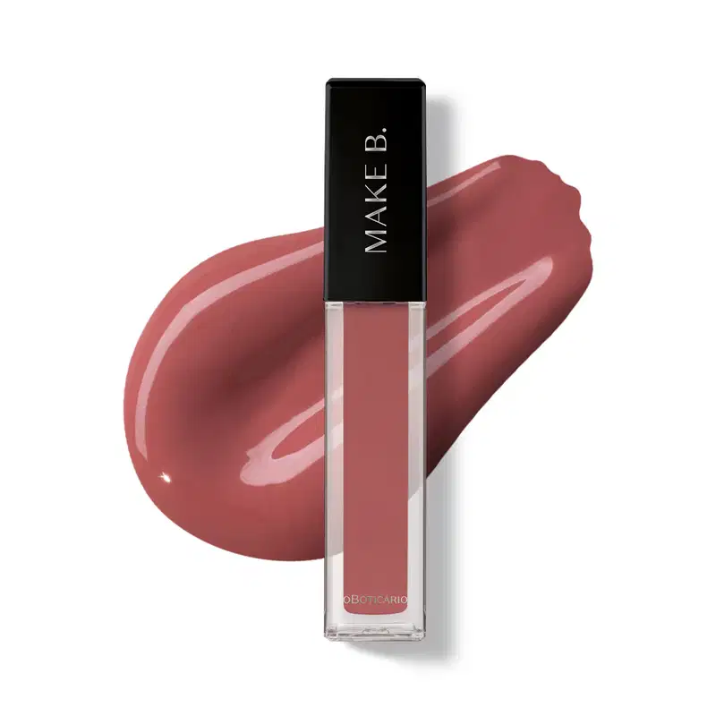 Gloss labial Rosa New Rose da marca Make B. em frasco retangular transparente com líquido rosa-acinzentado e tampa preta com logo da marca, exibido sobre superfície branca com aplicação do produto ao fundo mostrando textura e acabamento.