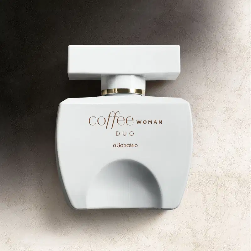 Vidro branco em formato quadrado com tampa da mesma cor em formato retangular, detalhes e letras douradas, contendo desodorante colônia Coffee Woman Duo posicionado em fundo preto e branco.