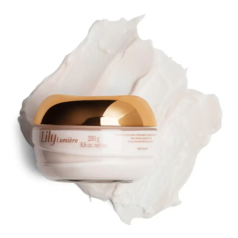 Pote de vidro com creme branco, tampa e letras douradas, contendo 250g de creme acetinado hidratante corporal da marca Lily Lumière com uma quantidade do produto espalhado ao fundo, mostrando a textura do produto.