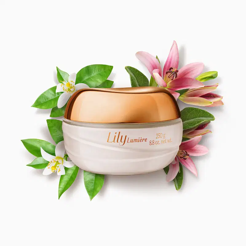 Pote de vidro com creme branco, tampa e letras douradas, contendo 250g de creme acetinado hidratante corporal da marca Lily Lumière, cercado por flores de lírio rosa e brancas com folhas verdes em fundo branco.