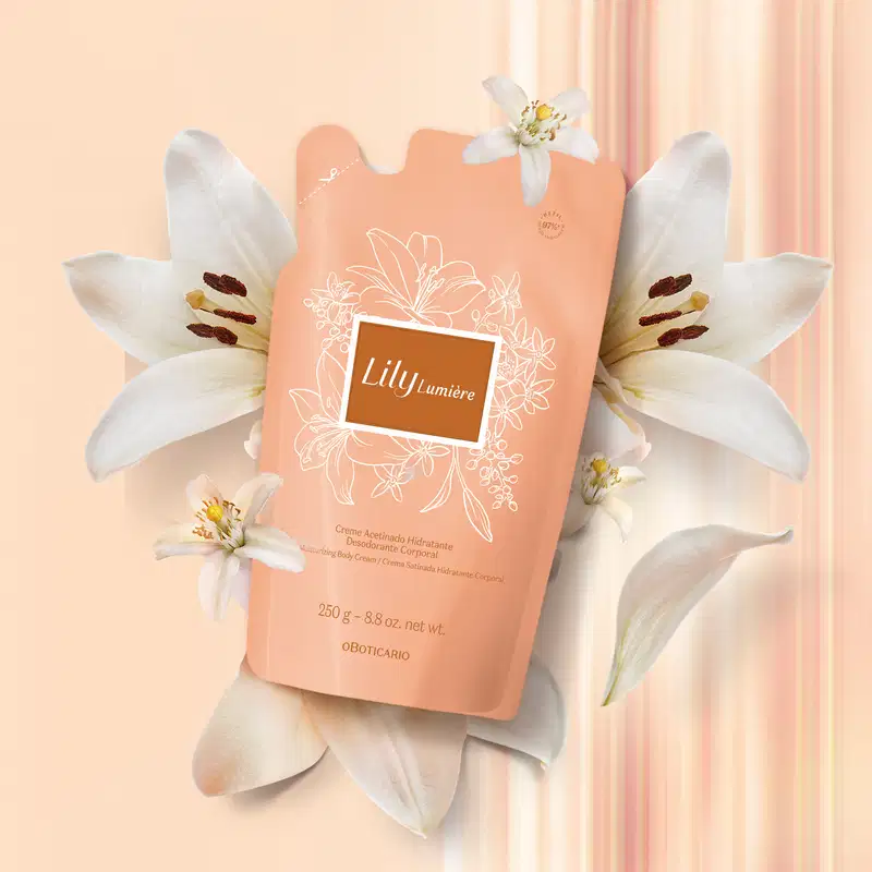 Refil de creme acetinado hidratante corporal da marca Lily Lumière em sachê de 250g na cor rosa com rótulo bege escuro, detalhes e letras douradas, sobre fundo bege com cortinas rosa.