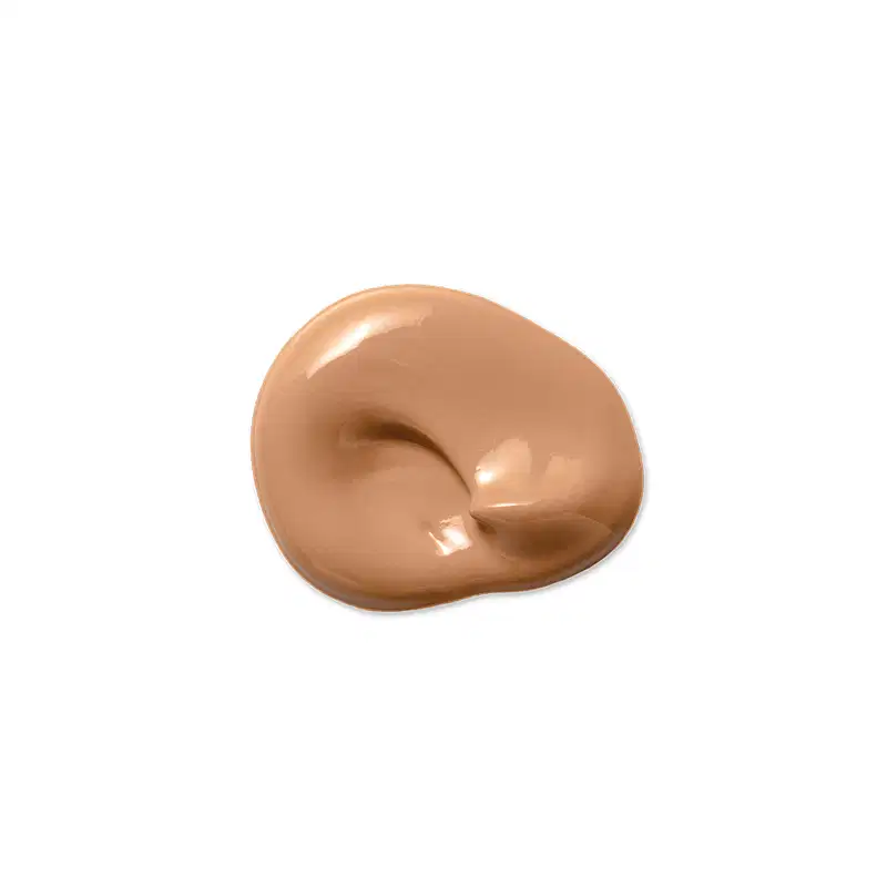 Textura de base líquida bege, com aspecto cremoso e brilhante, espalhada em formato orgânico sobre fundo branco liso, exibindo sombras suaves e pequenos reflexos de luz.