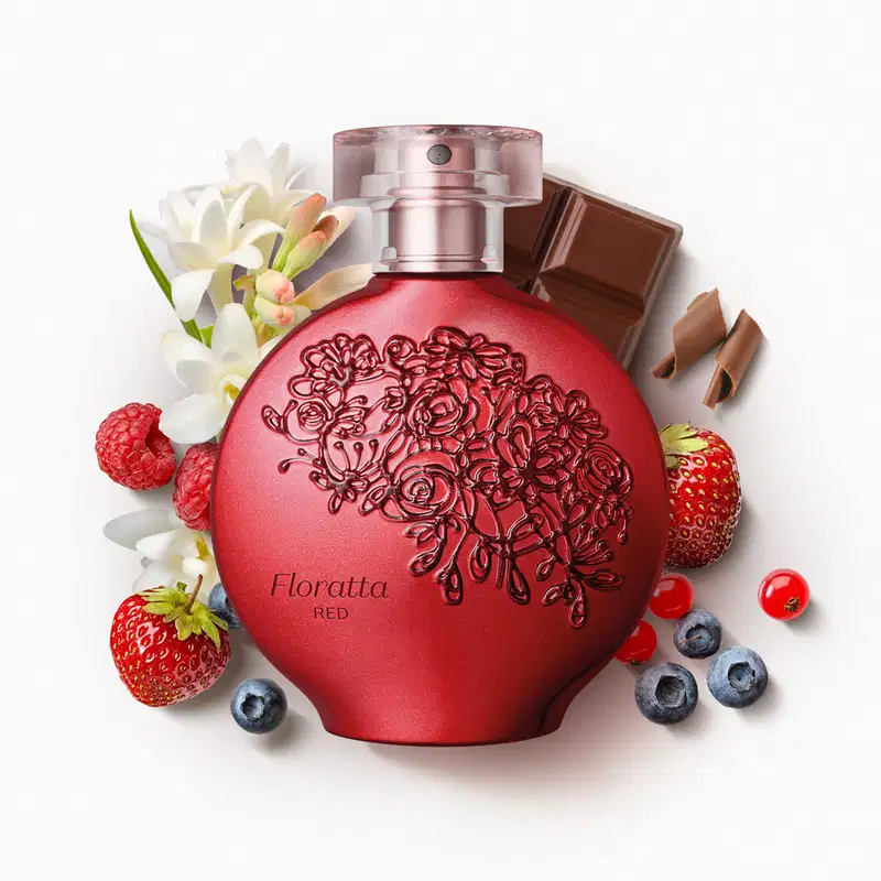 Perfume em frasco redondo de vidro vermelho com detalhes florais gravados. Rótulo "Floratta Red" visível. Acompanhado de flores brancas, morangos, mirtilos, pedaços de chocolate.