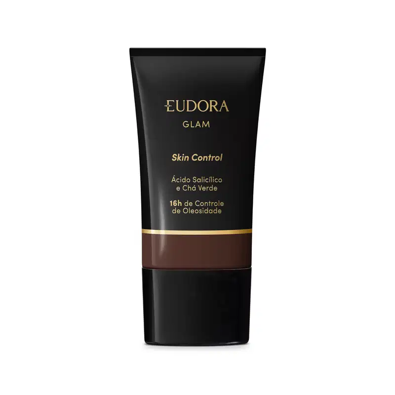 Embalagem plástica preta com detalhes em preto e dourado. Rótulo indica que é um Skin Control com ácido salicílico e chá verde, proporcionando 16 horas de controle da oleosidade. A cor da base é tom marrom escuro.