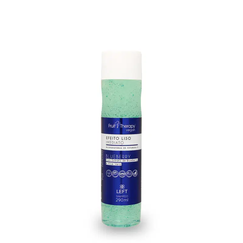 A imagem mostra um frasco transparente com rótulo azul e tampa branca de 290ml do shampoo da linha Fruit Therapy Vegan Blueberry, onde é possível ver o conteúdo esverdeado por dentro. O design traz informações sobre benefícios e composição.
