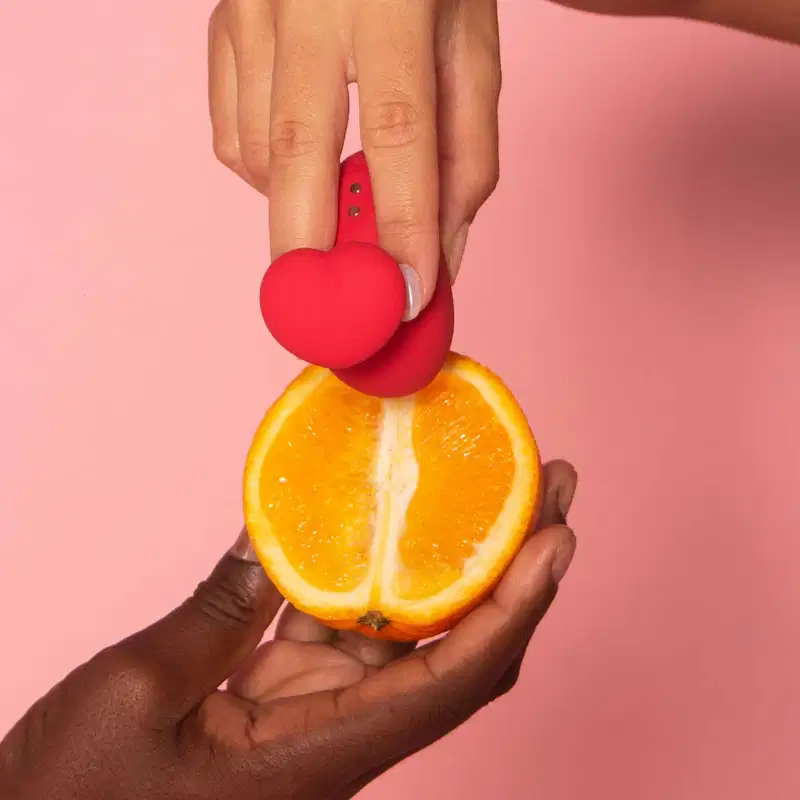 Mãos segurando uma laranja cortada ao meio e um acessório Désir Atelier