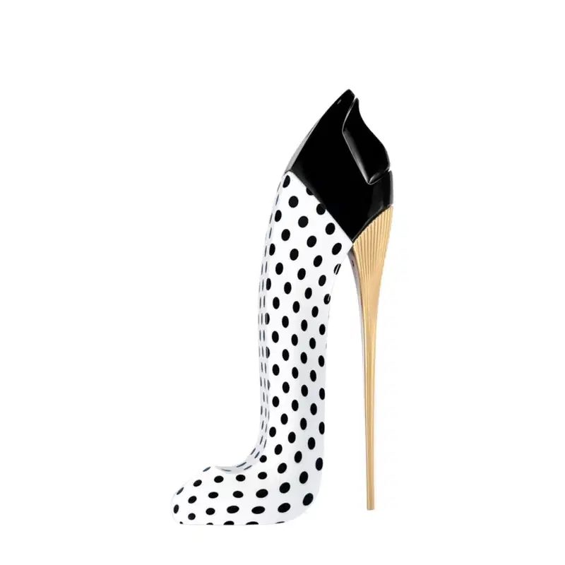 Frasco do perfume Good Girl Blush Polka Paradise em forma de sapato de salto alto com estampa de bolinhas pretas e brancas, com detalhes em dourado na parte superior e no salto. Embalagem elegante e minimalista, em preto e branco.